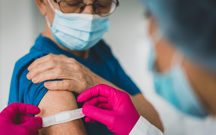 clinician putting a bandaid on a man's upper arm