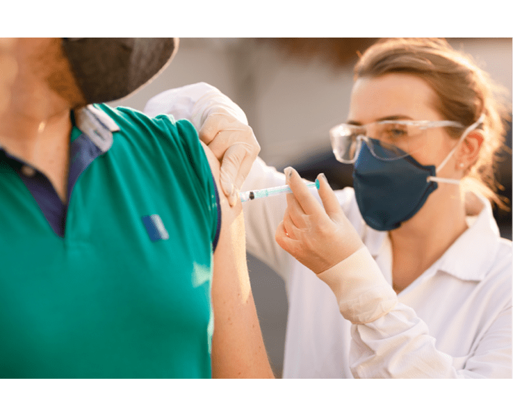 Masked female administering a flu shot